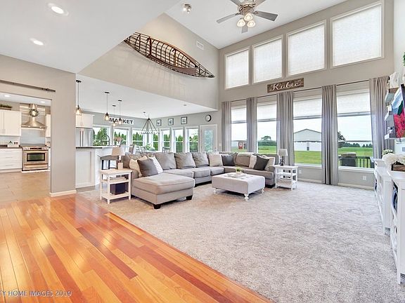 Two story foyer leads with hardwood floors leads to the two story great room with wall to ceiling windows.