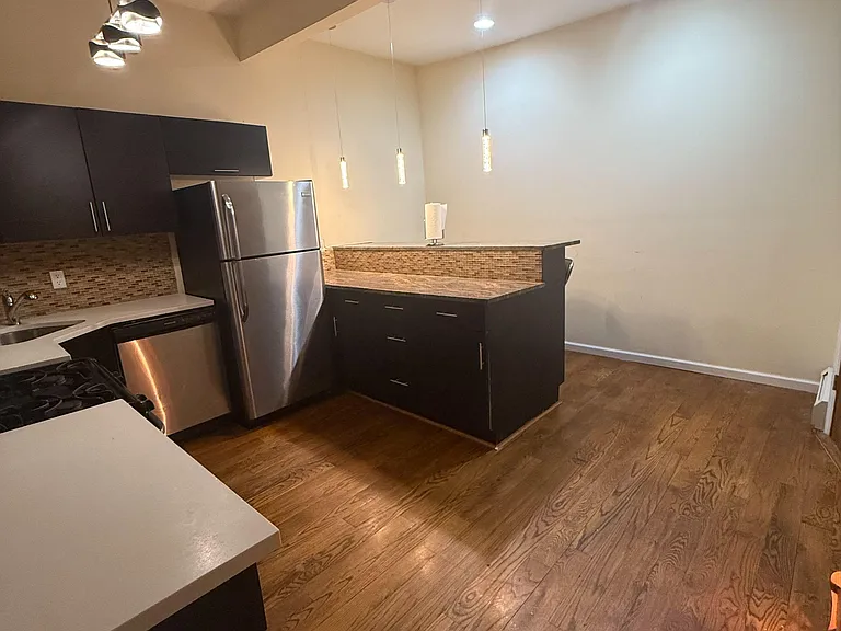 Open kitchen with breakfast bar, stainless appliances, and ample cabinetryideal for everyday cooking and casual dining.