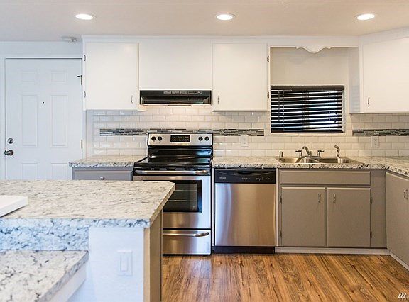 Kitchen offers stainless appliances, tile back-splash, laminate floors, can lights and new counters.