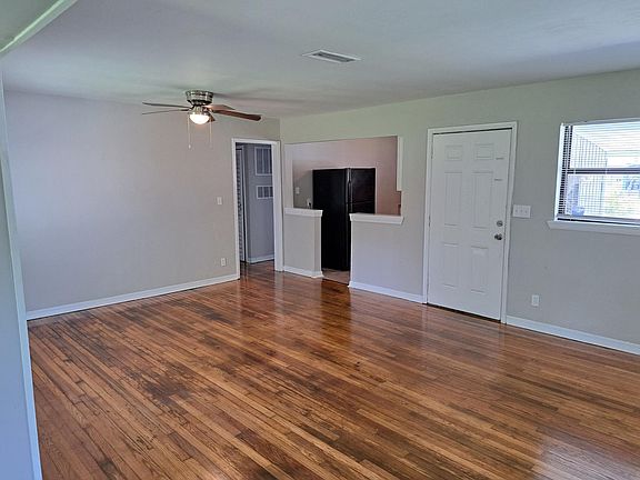 Living/Dining Room. Beautiful refinished real wood floors throughout. View facing newly renovated kitchen and front entrance.