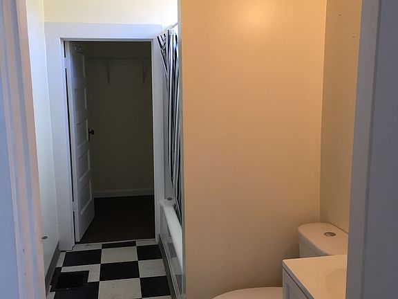Looking in bathroom from kitchen towards walk in closet
