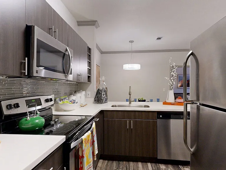 Apartment Kitchen with Quartz counter tops and Wood-Style Flooring.