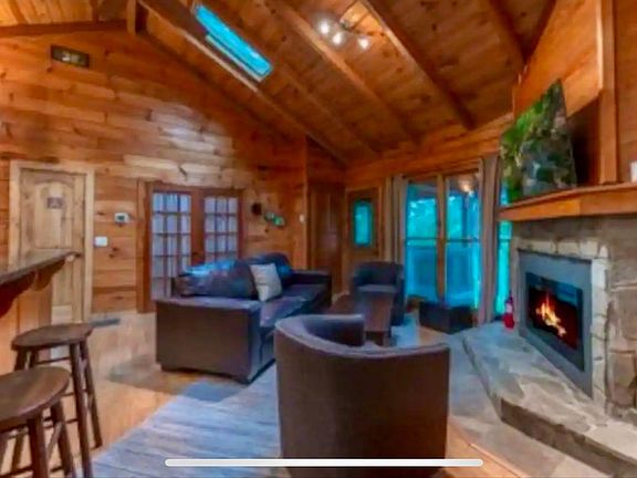 Vaulted family room with entrance to lower level, master bedroom, and screened in porch