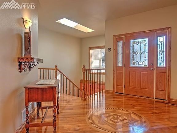 Another view of the entry showing iron railing stair way leading to walk out basement