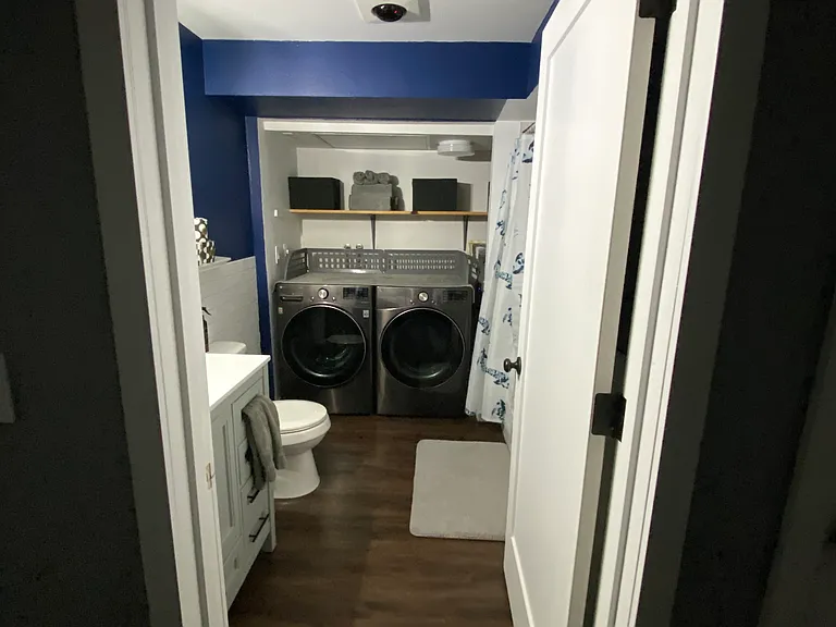 Bathroom with new washer and dryer, vanity, toilet, and hot water heater