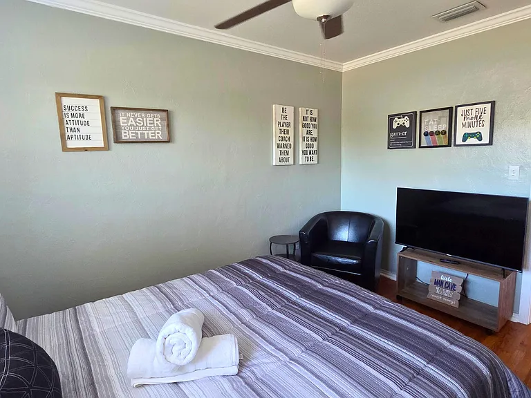Bedroom with Smart TV, decorative artwork, and cozy accent chair