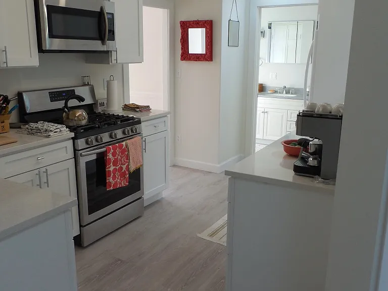 Kitchen, sky light and full bath in background.