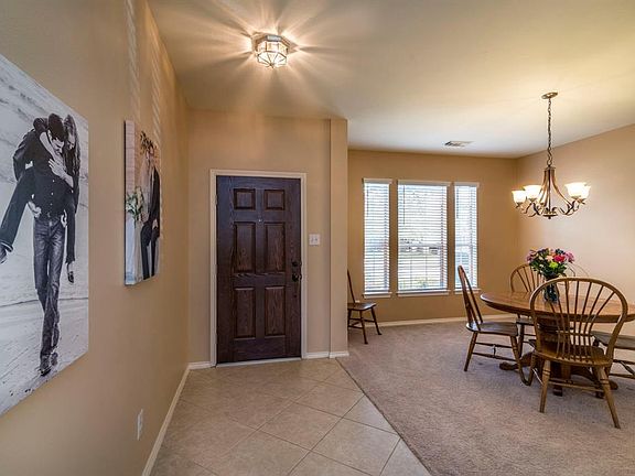 NEUTRAL TILED ENTRY SEPARATES YOUR ENTRANCE FROM THE DINING ROOM.