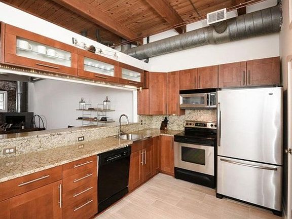 This modern kitchen has beautiful marble countertops and inc