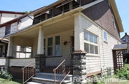 Corner view of house
						:
						Side door to basement steps. Brick drive leads to a detached two stall garage.