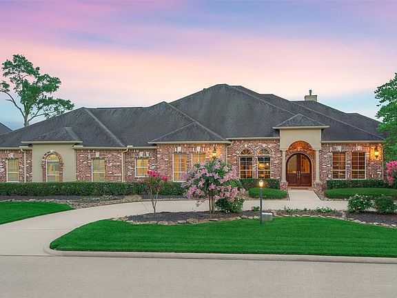 Home features full brick exterior, a circle drive for additional parking space, and vibrant landscaping.