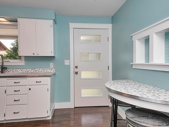 Kitchen looking at front door and breakfast table built-in.