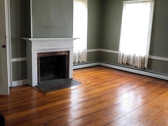 living room with closet and inoperable, original 1820s fireplace and mantel.