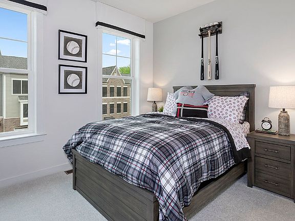 Secondary bedroom with two large windows in a DRB Homes Whitaker II model home.