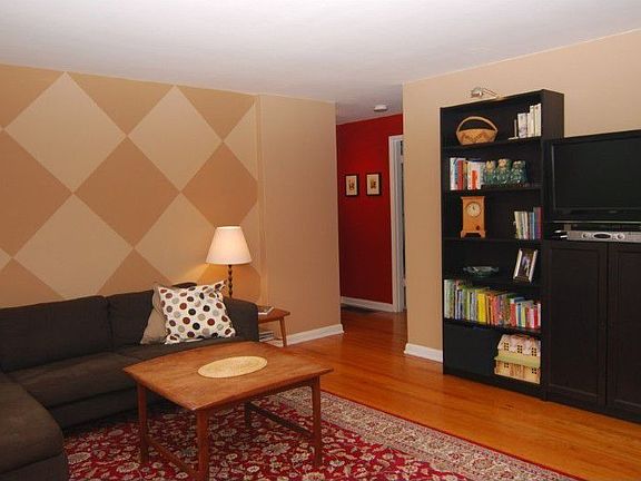 Spacious living room features hardwood floors, a large picture window & custom paint