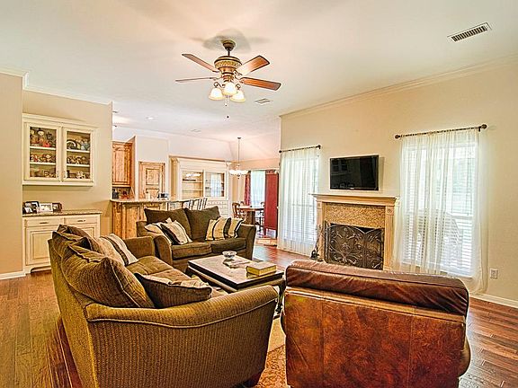 Generously sized den, or great room, boasts amazing hand scraped wood floors, a custom built-in unit