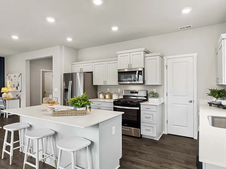 Kitchen with white cabinets and countertops. Stainless steel appliances. large walk-in pantry for storage.