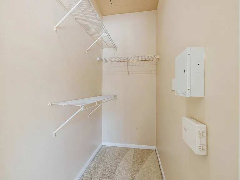 Spacious walk-in closet with ample shelving and storage options, perfect for organizing your wardrobe. Spacious walk-in closet with ample shelving and storage options, perfect for organizing your wardrobe.