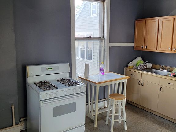 Kitchen Stove, Small Breakfast Table, Sink, and Cabinets