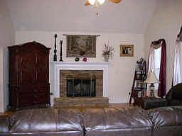 Living room with fireplace and vaulted ceiling.
