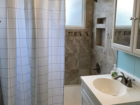 A recently tiled shower, with plenty of shelf space.
