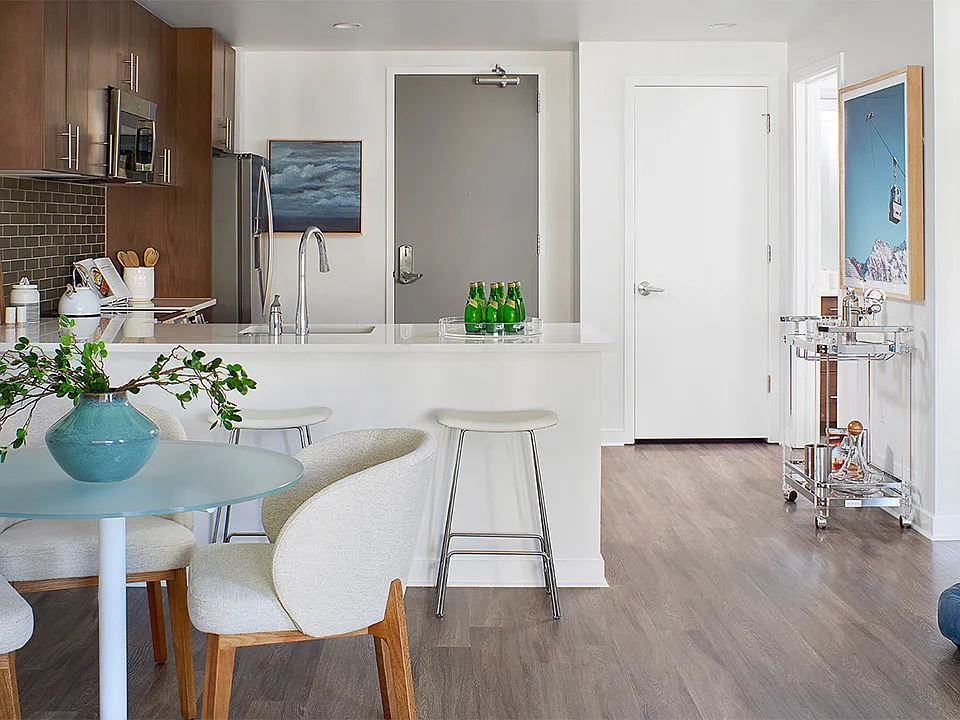 Apartment kitchen and dining room with wood-style flooring.
