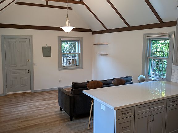 High ceiling living room & kitchen with tall seats for dining and entertaining