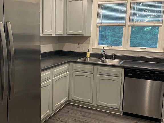 Kitchen with stainless steel appliances, new flooring and countertops