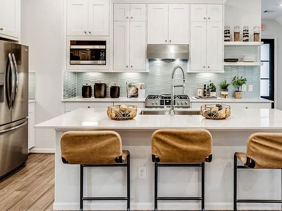 Prepare a delicious homecooked meal in the modern kitchen, which offers a flexible open layout, stai