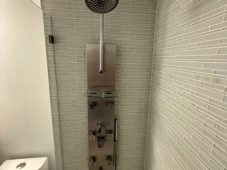 MASTER BATHROOM with limited-edition custom quartz countertop, large vanity mirror, dimmable designer lighting & step-in shower with spa massage jets
