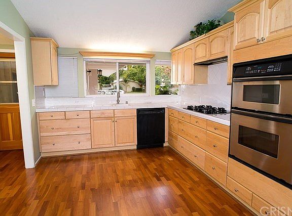 The remodeled kitchen offers maple cabinets, clean tile counter tops, a gas range, electric oven, a 