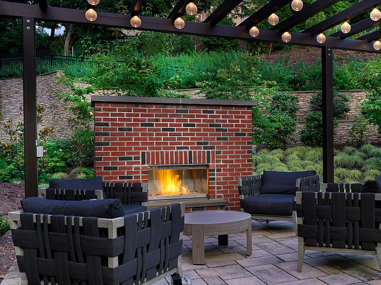 Experience relaxation in our stylish outdoor amenity space, complete with a cozy fireplace and comfortable seating.