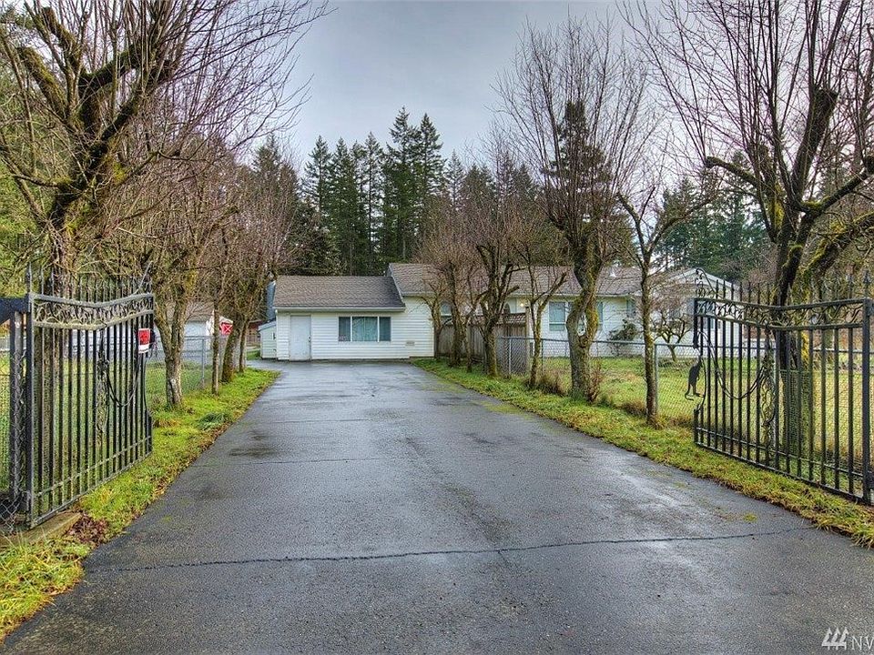 Gated entry with a long paved driveway all the way to the home and detached garage.