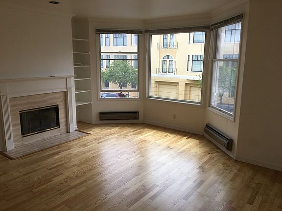 Living room w/ bay windows and FP