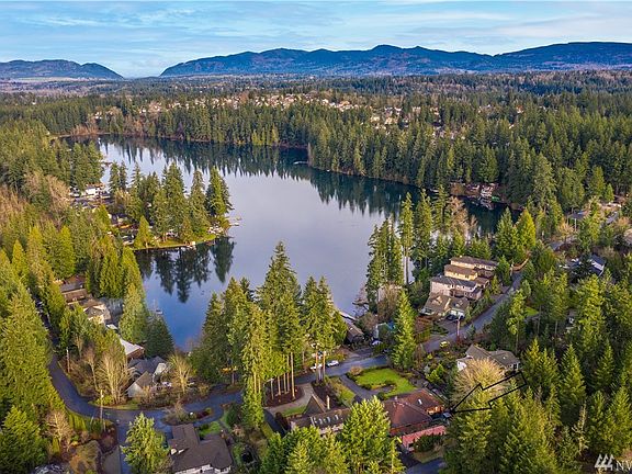 Serene lake view setting with expansive front yard.
