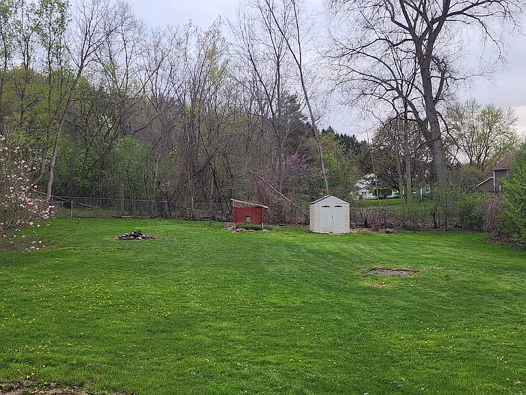 Backyard with one shed. Chicken coop can be repurposed or removed later in summer. There is a gate in the back to access the trails and town land.