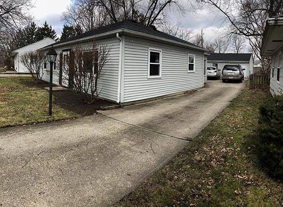 Driveway with view of detached one car garage
