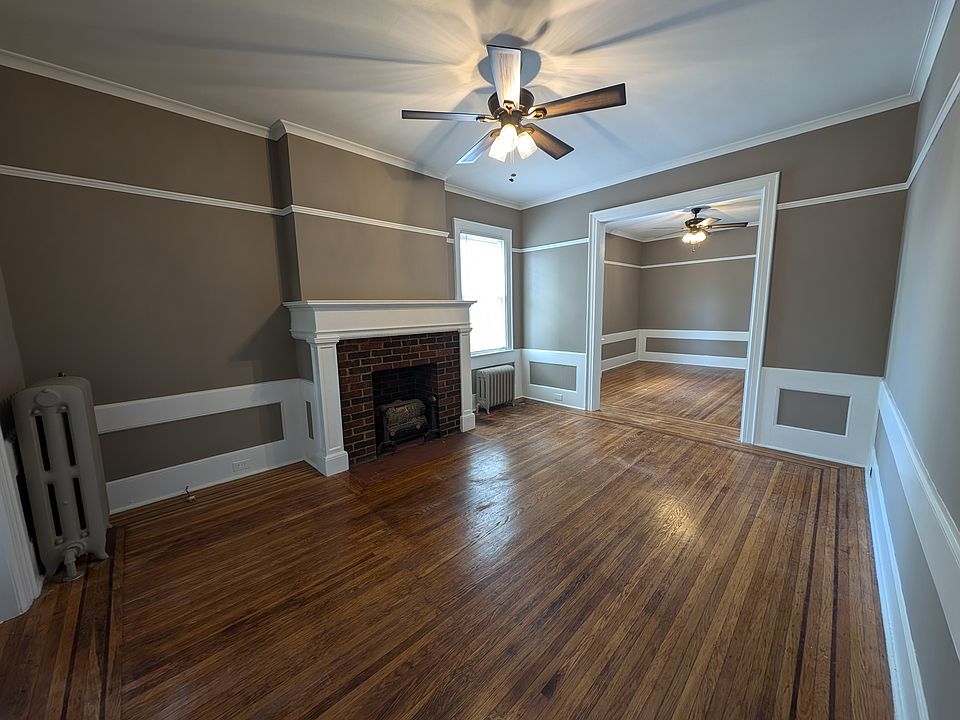 Front Entry into Apartment w decorative fireplace and ceiling fan