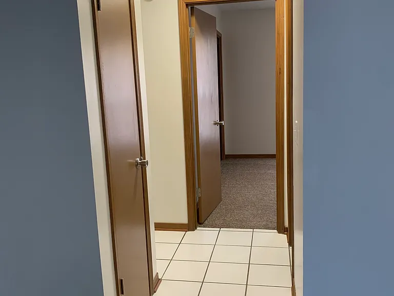 Tiled hallway with closet and guest bedrooms and bathroom.