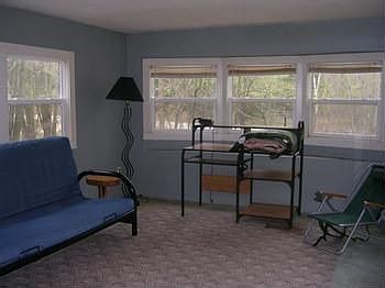 The living room has many windows for natural lighting.
