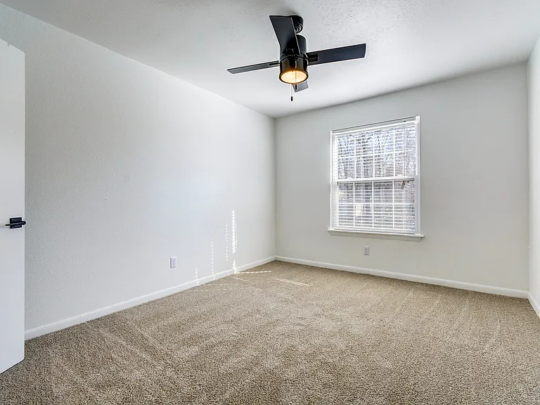 A carpeted bedroom with oversized closet and ceiling fan is shown at ReNew on Cantrell.