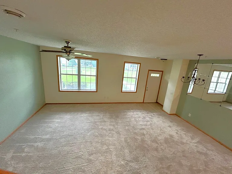 15' wide x 20' length Family room without furniture with tall windows. Door leads to private sit in patio overlooking huge open backyard with walking trail.