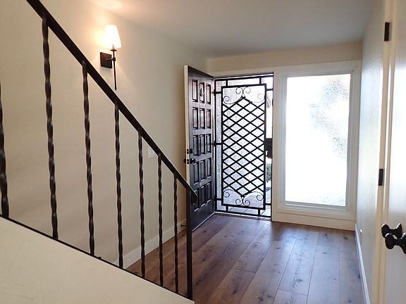 Entry with stylish security door, beautiful staircase, double door closet and large, obscure window for natural light