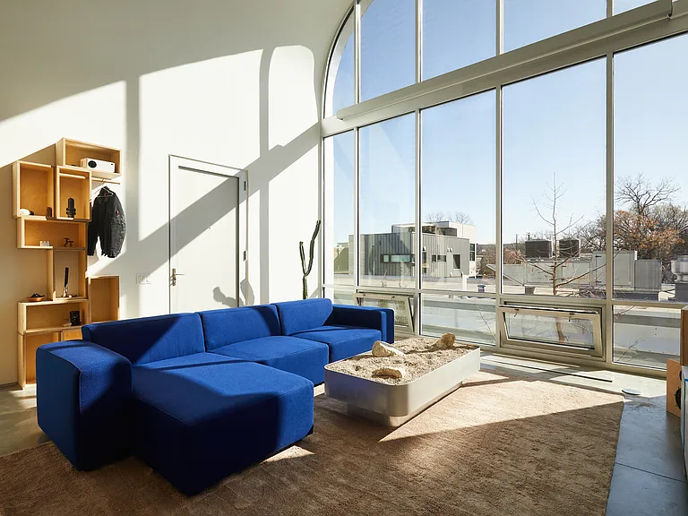 Living room with art deco couch, sculptures and wall art with floor to ceiling windows