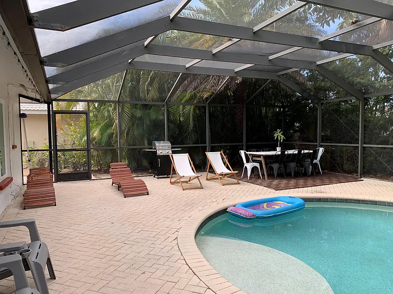 Pool and deck with outdoor furniture, a grill and a ding table sits 6 people.