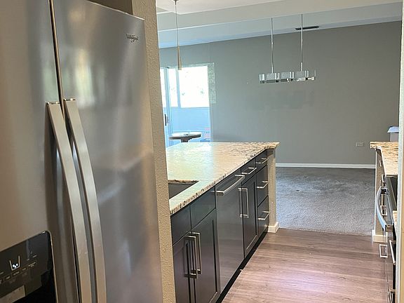 New refrigerator with view to dining room and bright light of the balcony beyond