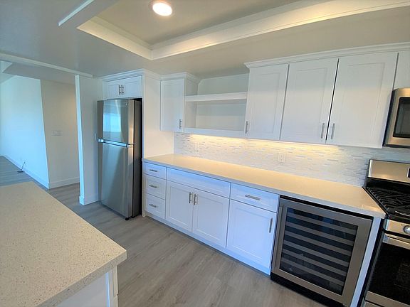 Large kitchen with brand new appliances including a beverage (wine) refrigerator. Beautiful under cabinet lighting, beautiful tile backsplash and countertops. Neutral, clean and elegant.