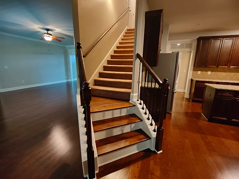 The stairway is between living room and kitchen.