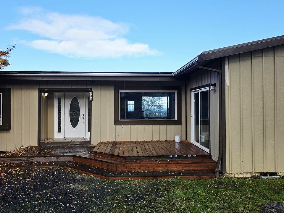 Front of house with walk in deck and sliding glass door to kitchen