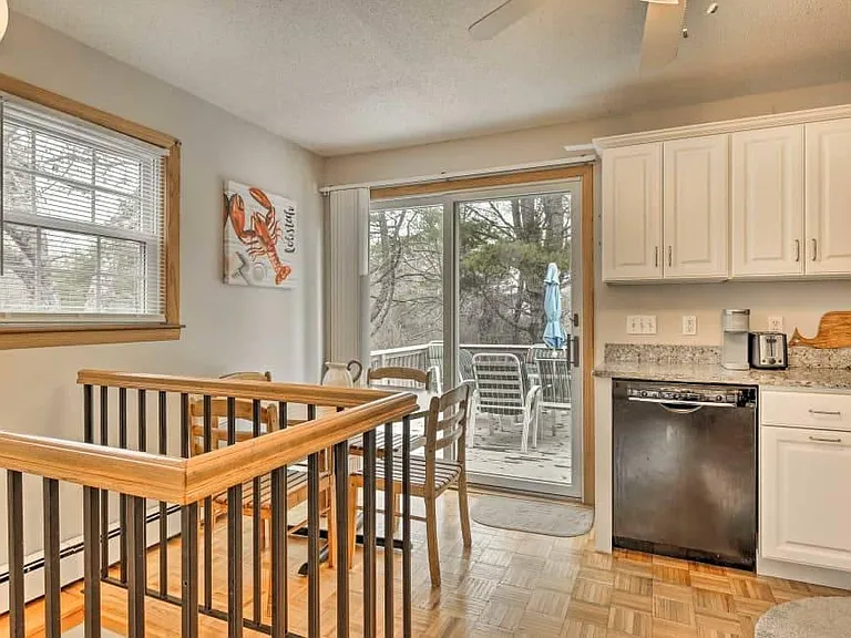Kitchen looking out to back deck, spiral stair case down to finished basement / game room on left.